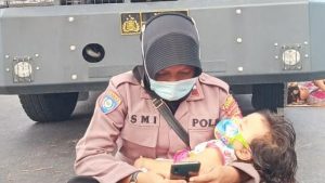 Aksi Polwan Gendong Anak Sembari Jaga Aksi Demo, Viral